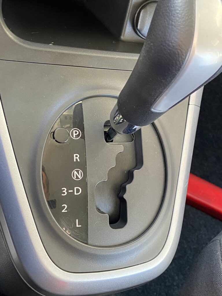 Automatikgetriebe Schalthebel in einem Auto, Stellung auf 'P' für Parken, zeigt verschiedene Fahrmodi.