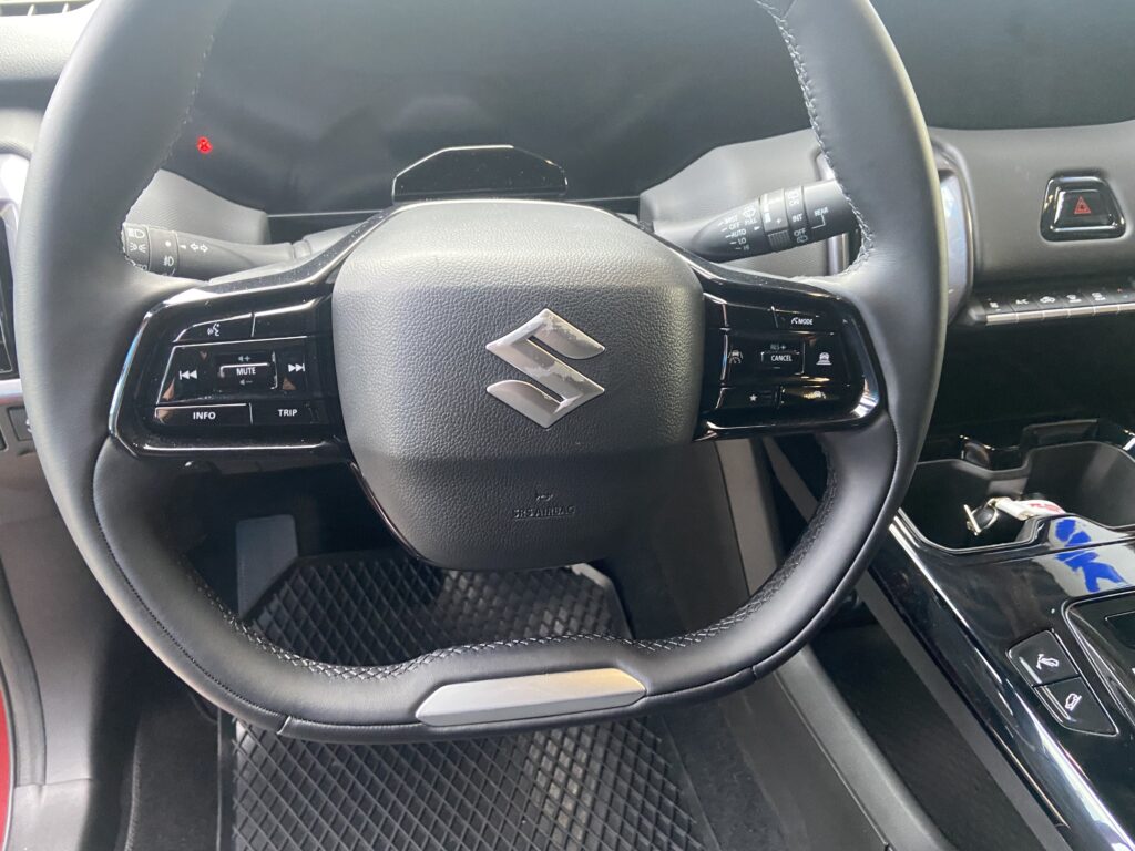 Lenkrad eines Suzuki mit Bedienelementen. Moderne Fahrzeugtechnik im Innenraum mit Multifunktionstasten.