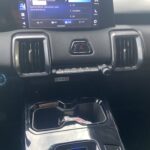 Nahaufnahme eines modernen Auto-Armaturenbretts mit Touchscreen-Display und zentralem Getriebewähler.