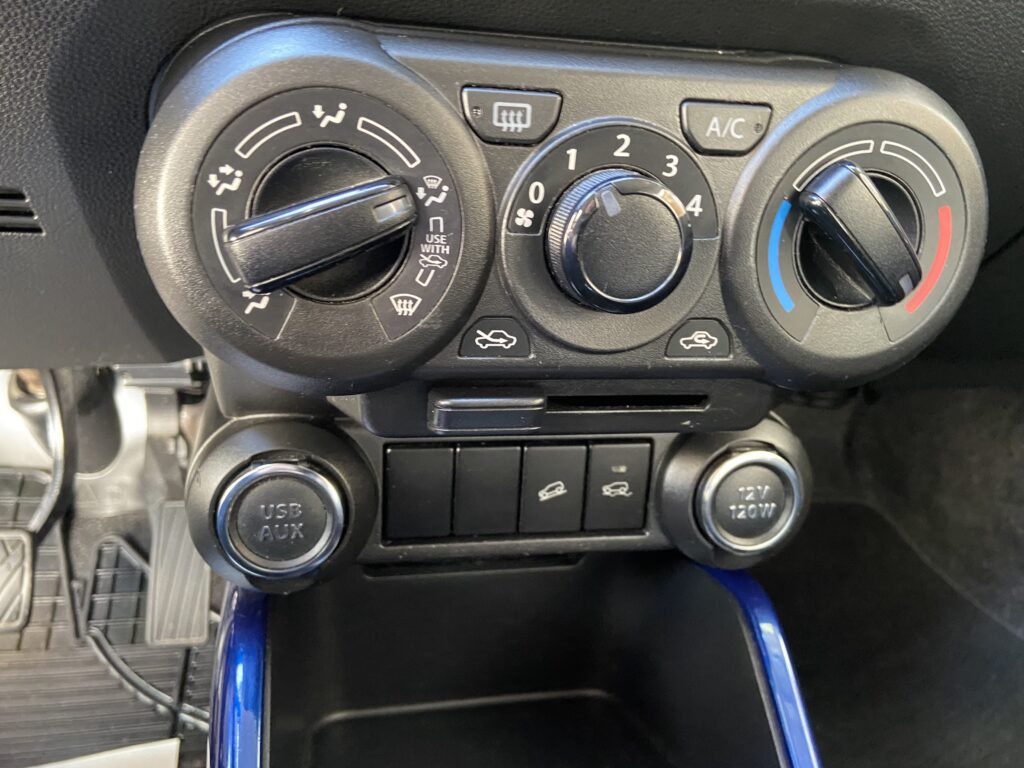 Auto-Klimaanlagensteuerung mit Temperatur- und Lüfterreglern sowie USB- und 12V-Anschluss im Armaturenbrett.