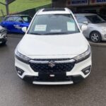 Weißer Suzuki SUV im Freien mit Angebotsplakaten, präsentiert bei einem Autohaus-Event.