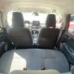 Auto-Innenraumansicht von hinten, zeigt Sitzanordnung und Armaturenbrett mit mäßiger Beleuchtung.