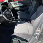 Innenansicht eines neuen Autos mit grauem Interieur und modernem Design, hell beleuchtet.