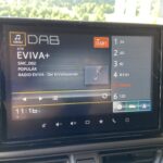Autoinnenraum mit Digitalradio-Display, das DAB-Sender „EVIVA+“ anzeigt, 11:16 Uhr.