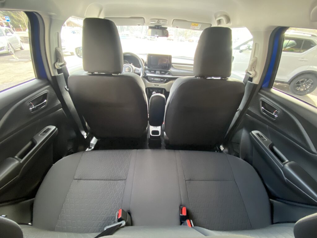 Innenraum eines Autos von hinten gesehen, zeigt schwarze Sitze und ein modernes Armaturenbrett.