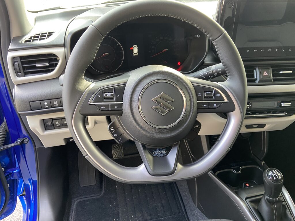 Innenansicht eines Suzuki-Autos mit Fokus auf das Lenkrad und das Armaturenbrett.
