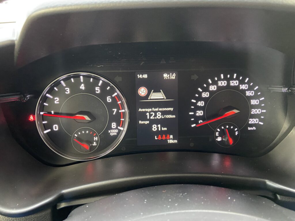 Autotacho mit Geschwindigkeitsanzeige, Drehzahlmesser und digitaler Anzeige von 12,8L/100km Kraftstoffverbrauch.