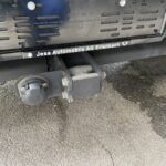 Anhängevorrichtung und Steckdose an einem Fahrzeug von Jesa Automobile AG, Erlenbach, abgebildet auf Asphaltboden.