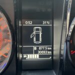Armaturenbrett mit geöffnetem Türen-Symbol, 31°C, 877,5 km Fahrstrecke, 30693 km Gesamtkilometerstand.