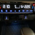 Auto-Klimaanlage Bedienfeld mit Temperaturanzeige, Tasten für Lüfterstufen und Sitzheizung.