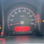 Tachometer eines Autos mit roten und gelben Warnleuchten bei 99966 Kilometern, Geschwindigkeit auf 0 km/h.