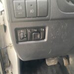 Armaturenbrett-Autosteuerung mit Nebelscheinwerfer- und Rückspiegelknöpfen, schwarz, Nahaufnahme.
