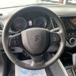 Lenkrad und Armaturenbrett eines Suzuki Autos mit Multimedia-Display und Tachometer.