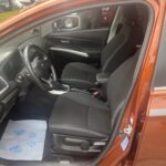 Innenansicht eines modernen Autos mit schwarzen Sitzen und einem stilvollen Armaturenbrett.