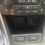 Mittelkonsole eines Autos mit Klimasteuerung, Temperaturanzeige und Sitzheizungsschaltern.