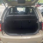 Geöffneter Kofferraum eines beige SUV auf einem Parkplatz mit Autos im Hintergrund.