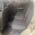 Rückbank eines beige Autos mit grauem Stoffbezug, zeigt geräumigen Innenraum und schwarze Teppichmatten.