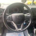 Lenkrad eines Suzuki-Autos mit Bedienfeld im Innenraum, Blick auf Tachometer und Armaturenbrett.