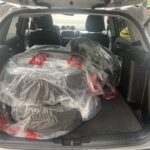 Autoreifen in Schutzfolie im Kofferraum eines Fahrzeugs verpackt. Bereit für den Transport oder die Lagerung.