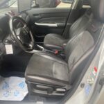 Innenansicht eines Autos mit Leder- und Stoffpolstern, schwarzem Lenkrad und modernen Armaturen.