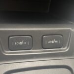 Zwei Knöpfe für Sitzheizung im Auto, einstellbar auf Low oder High, in schwarzer Konsole.