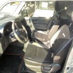 Innenraum eines Autos: Schwarze Ledersitze, Lenkrad und Armaturenbrett bei Tageslicht.