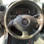 Lenkrad und Armaturenbrett eines Suzuki-Autos, Innenansicht mit Tacho und Schaltknüppel sichtbar.
