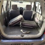 Auto-Kofferraum mit umgeklappter Rückbank und abnehmbarer Anhängerkupplung, ideal für Transportzwecke.