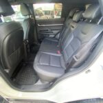 Rückansicht eines Autos mit schwarzen Ledersitzen und offener Tür, Blick auf geräumigen Innenraum.