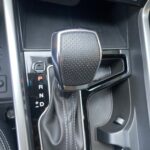 Nahaufnahme eines Automatikgetriebeschalthebels im Auto mit sichtbaren Fahrstufenanzeigen.