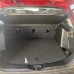Offener Kofferraum eines roten Autos mit umgeklappter Rückbank für mehr Ladefläche.