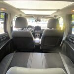 Innenansicht eines Autos mit Ledersitzen und modernem Armaturenbrett bei Tageslicht.