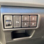 Armaturenbrett eines Autos mit Schaltern für Scheinwerfer, Parksensoren, Stabilitätskontrolle und weitere Funktionen.