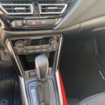 Innenraum eines Autos mit Schwerpunkt auf Schalthebel und Klimabedienung in der Mittelkonsole.