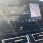 Multifunktionales Autodisplay zeigt Navigation, Radio und Einstellungen bei Sonneneinfall.