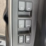 Auto-Fensterhebel und Kontrollknöpfe an der Autotürverkleidung, Nahaufnahme, modern und funktional.
