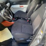 Innenraum eines Suzuki Ignis mit schwarzen Sitzen und roten Akzenten, Fahrer- und Beifahrersitz im Blick.